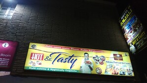 A restaurant signboard advertising 'HOT & Tasty' with multi-culinary offerings and hygienic services. - Hotel Anjali (Deoghar)