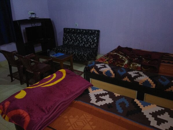 Una habitación con una cama, un sofá, una mesita y una silla.
