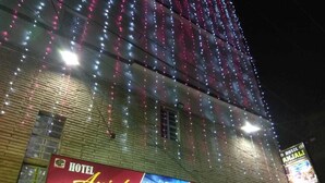 Ein Hotel mit einem großen Schild, das "HOTEL Anjali" und "Alle Raumtypen" bewirbt.