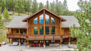 A large log cabin with a balcony and outdoor seating area. - Luxury Log Cabin Near Cascade Lake, 80 Acres, RVs (Cascade)