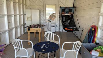 Relax and play in this cozy game room with a foosball table, basketball hoop, and sports equipment.