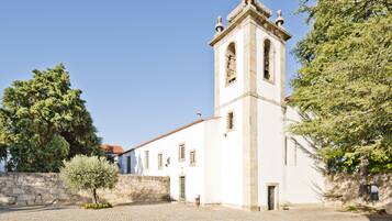 A historic building with a bell tower, stone walls, and a cobblestone courtyard.