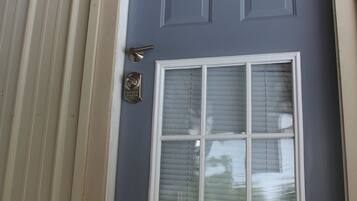 A front door with a window, a doorbell, and a mailbox.