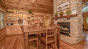 A wooden interior with a stone fireplace, wooden furniture, and built-in cabinets.