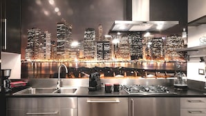 Una cocina moderna con vistas a la ciudad, electrodomésticos de acero inoxidable y una cafetera.
