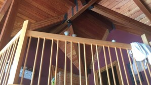 A wooden balcony with a railing, supported by wooden beams and metal brackets.