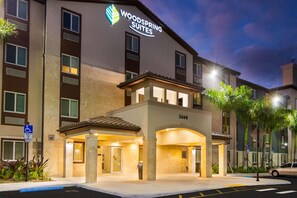 A hotel with a sign reading "Woodspring Suites" and a handicap accessible entrance. - WoodSpring Suites Miramar (Miramar)
