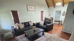Uma sala de estar espaçosa com um amplo sofá modular, uma mesa de centro e um tapete estampado.