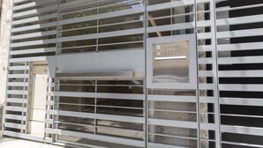 A metal gate with horizontal bars and a rectangular metal plate with numbers. - Lafinur by Be Local Argentina (Buenos Aires)