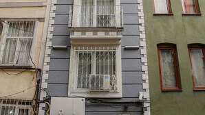 Un edificio de varios pisos con balcones, un letrero que dice 'Reggae Hotel Apart' y una puerta visible.