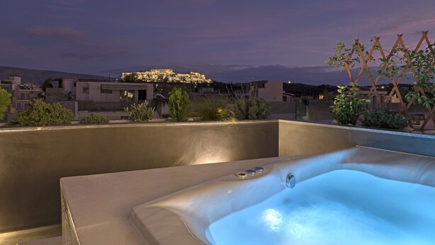 Un jacuzzi sur le toit offrant une vue sur le paysage urbain au crépuscule.