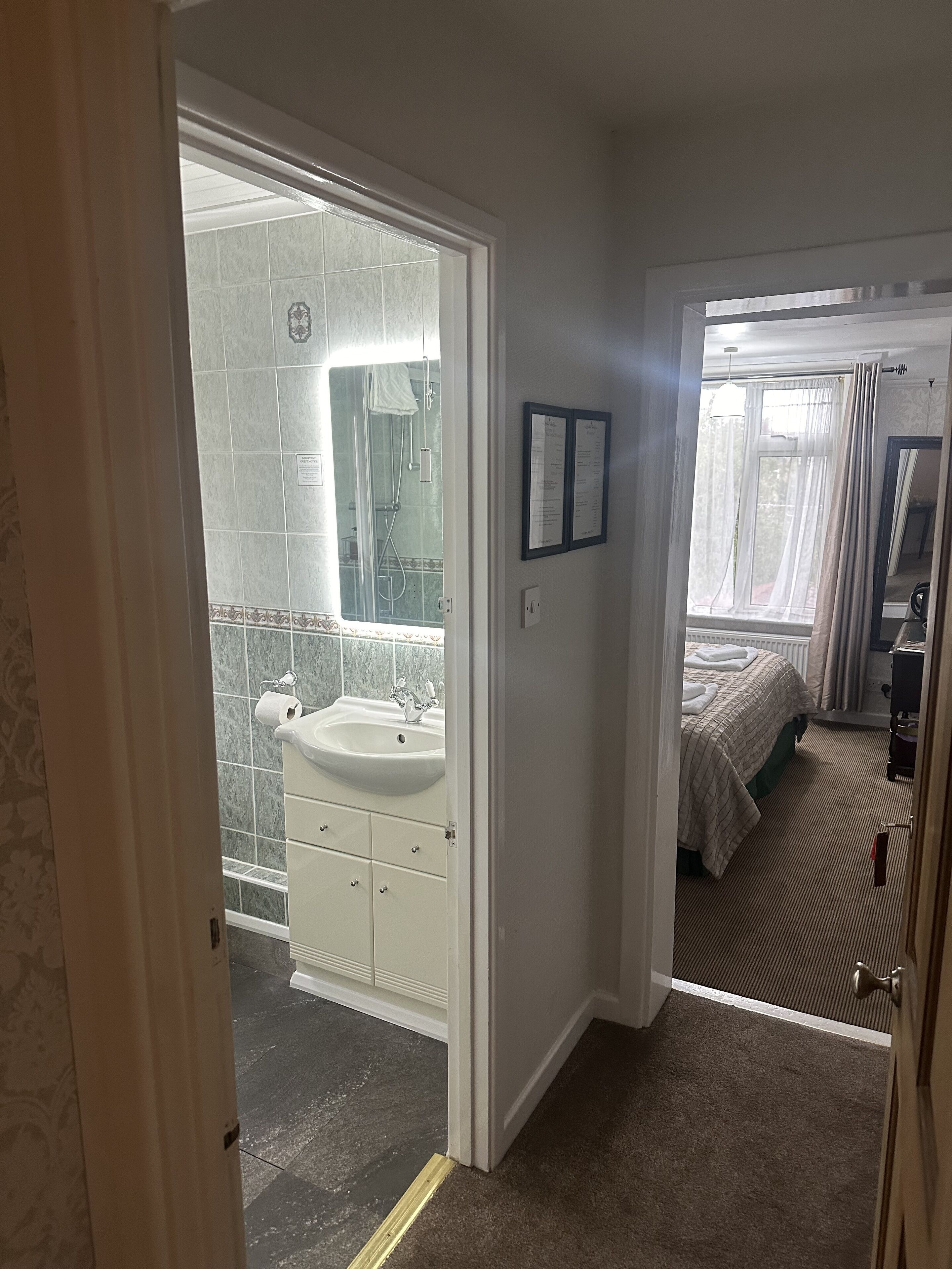 Un bagno d'hotel con lavandino, specchio e doccia.