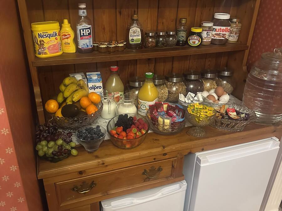 A kitchen counter with various food items, including fruits, condiments, and jars.