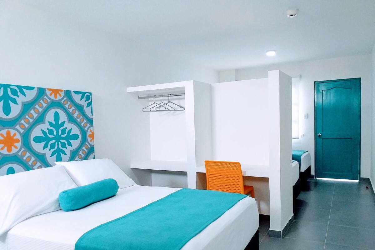 Ein Hotelzimmer mit Bett, Schreibtisch, Stuhl und einer Badezimmertür.