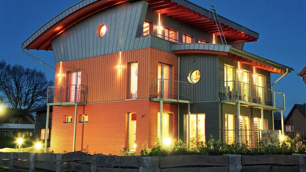 Un immeuble moderne à plusieurs étages, doté d’un toit plat, de grandes fenêtres et d’un balcon.