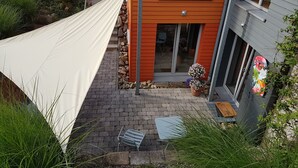 Une maison moderne dotée d’une terrasse, d’un hamac et d’un paillasson accueillant.
