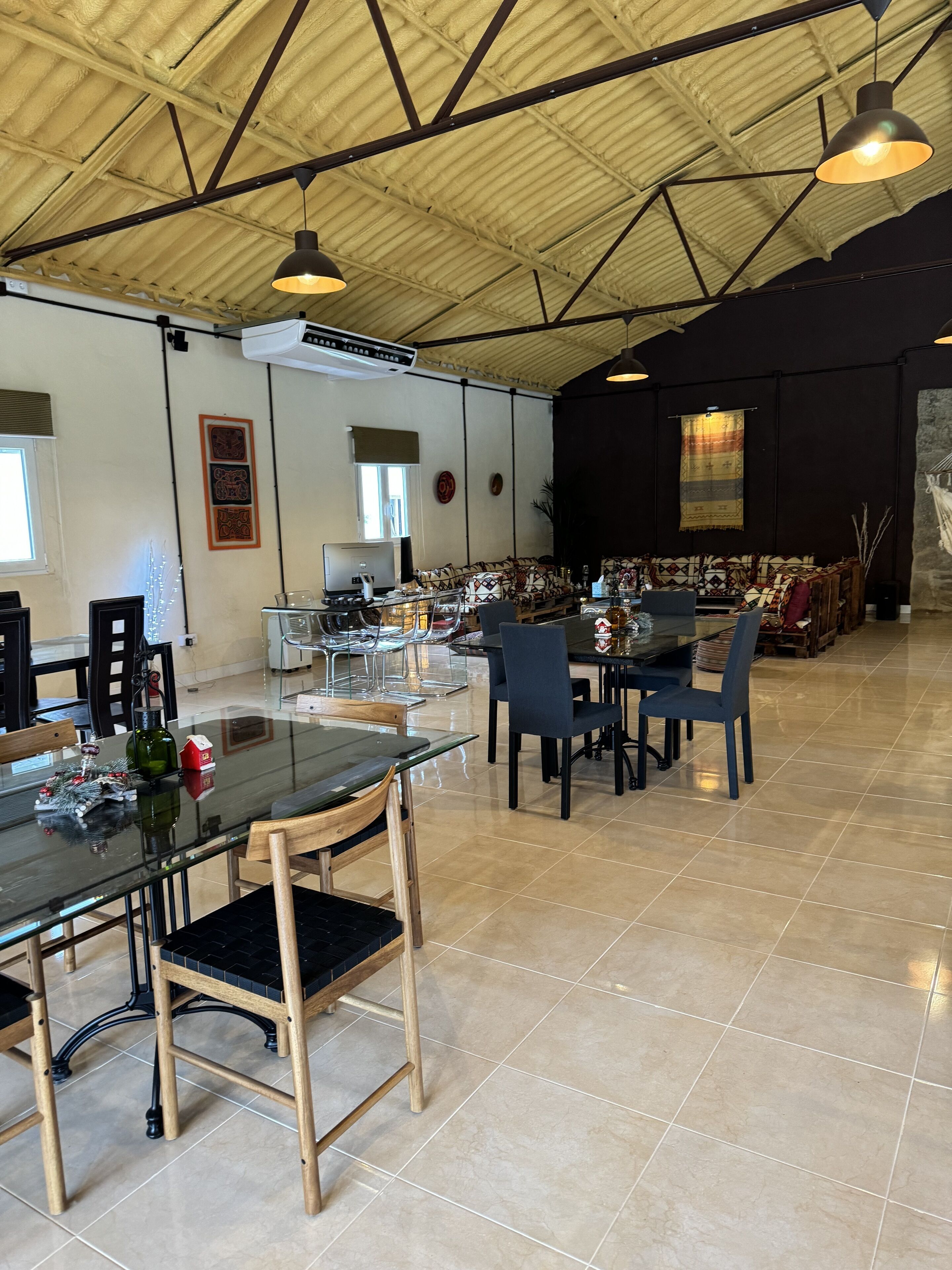 Un comedor espacioso con techo alto, muebles modernos y una variedad de opciones de asiento.