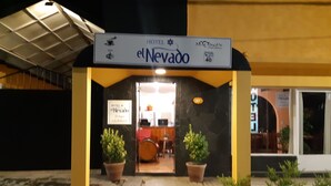 The exterior of Hotel el Nevano with a sign above the entrance, potted plants, and a visible interior through the doorway. - Hotel El Nevado Malargüe (Malargüe)