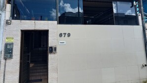 A building with a large window, a door, and the number 679 on the wall. - Lar Recife Olinda (Recife)