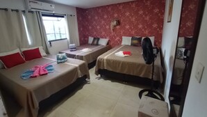 A hotel room with two beds, a window with curtains, a wall-mounted air conditioner, and a standing fan. - Lar Recife Olinda (Recife)