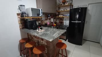 Refrigerador em uma área comum, micro-ondas, fogão, liquidificador