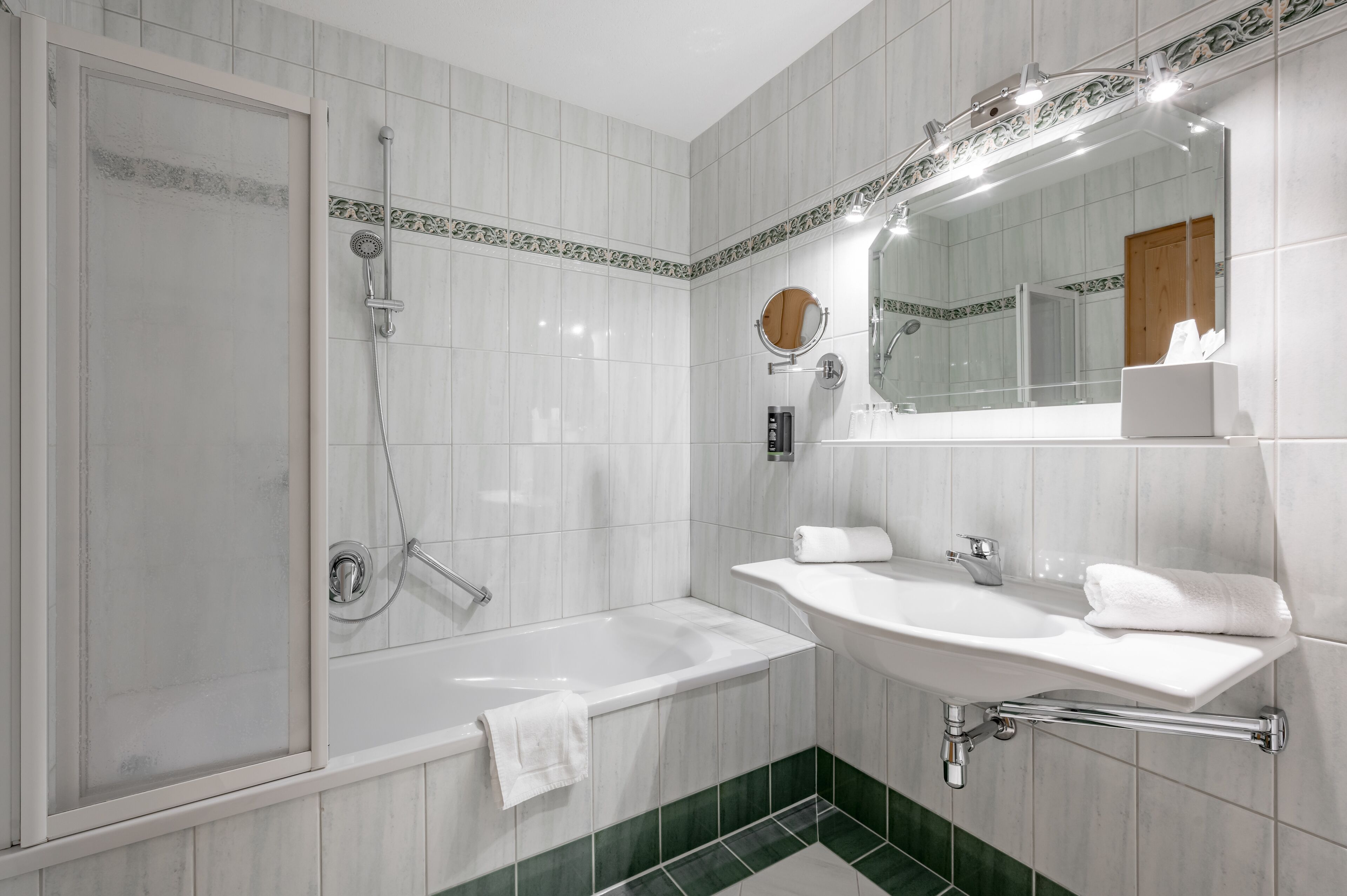 A modern bathroom with a glass-enclosed shower, a freestanding bathtub, and a vanity with a mirror.