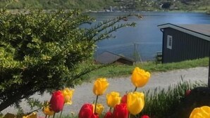 A mountainous landscape with a lake and a small building.