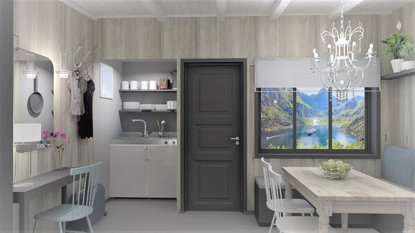 A modern kitchen with a grey door, a dining table with chairs, a chandelier, and a window with a scenic view.