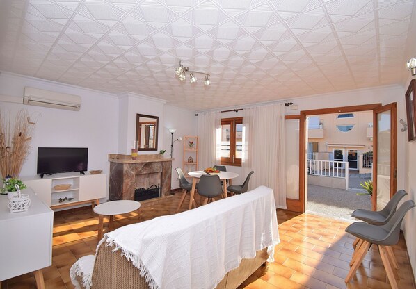 A living room with a TV, fireplace, dining table, and chairs. - Starfish 146 holiday home with terrace, air conditioning and WiFi (Can Picafort)
