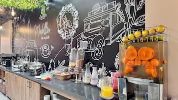 Una barra de desayuno con diversos alimentos y una pared de pizarra con dibujos.