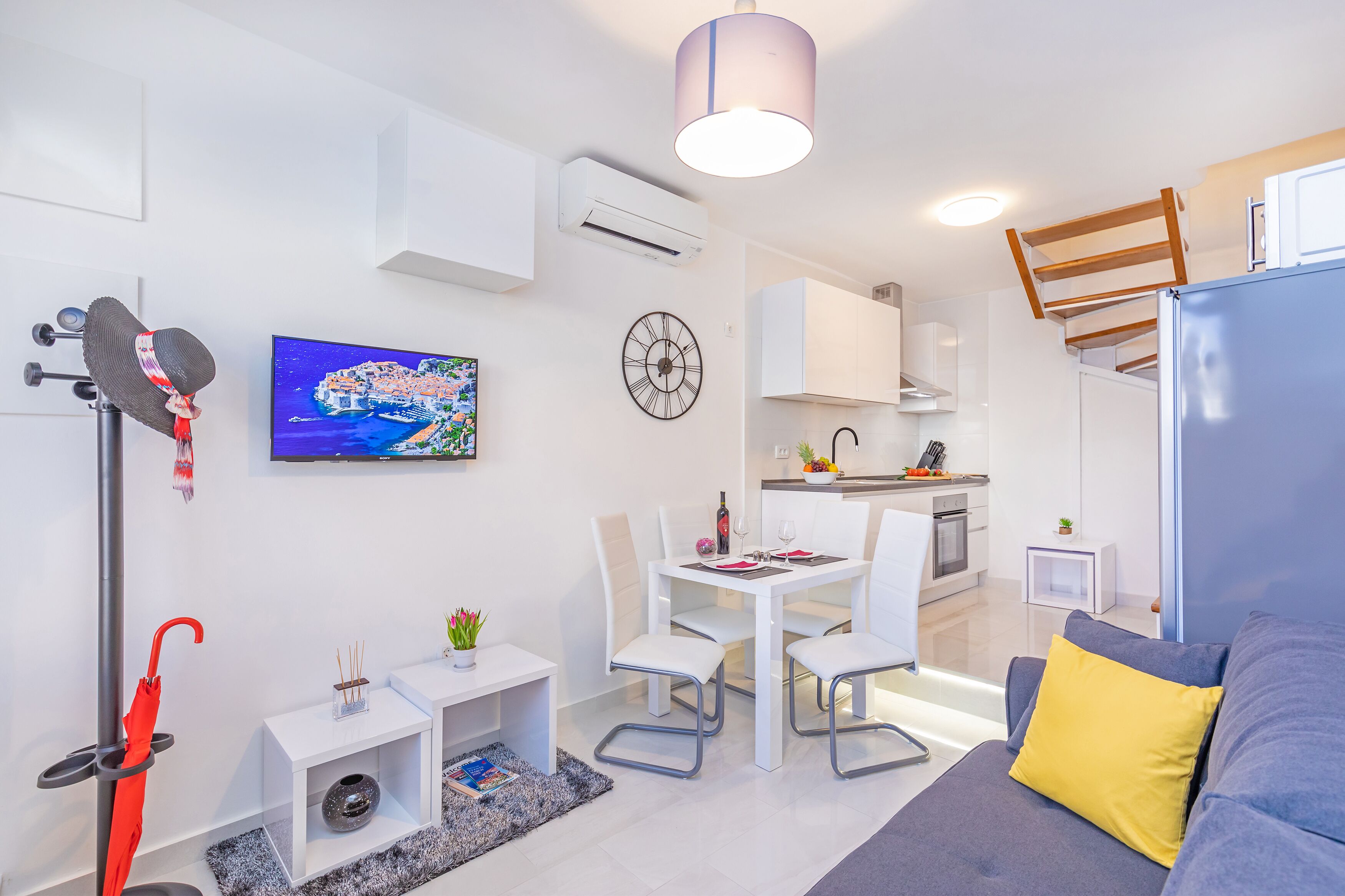 A modern, compact living space with a dining area, kitchenette, and a cozy seating area.