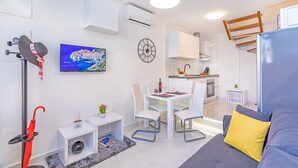 A modern, compact living space with a dining area, kitchenette, and a cozy seating area. - Apartment Sendi - Near the beach, fully equipped (Dubrovnik)