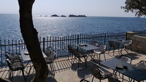 An outdoor seating area with tables and chairs, overlooking the sea. - Apartment Sendi - Near the beach, fully equipped (Dubrovnik)