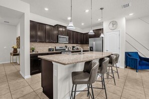 Enjoy cooking in this kitchen with a central island, stainless steel sink, and microwave.