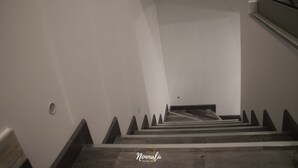 Una escalera con escalones de madera y paredes blancas.