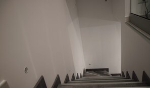 Una escalera con escalones de madera y paredes blancas.