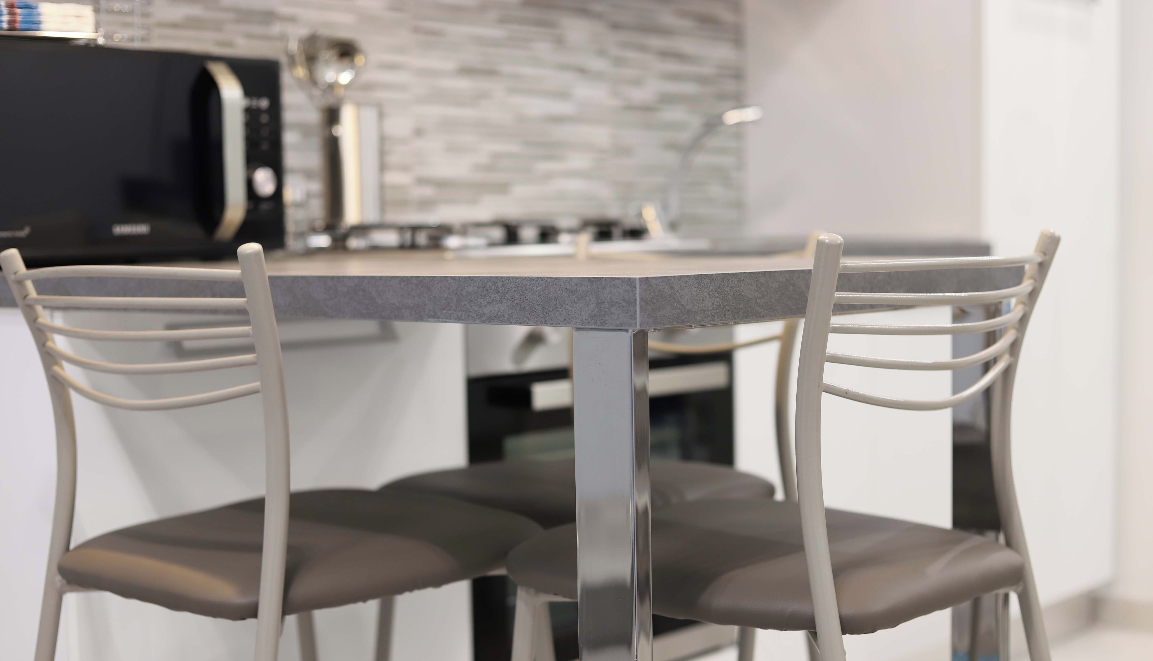 Une cuisine moderne avec une table et des chaises.