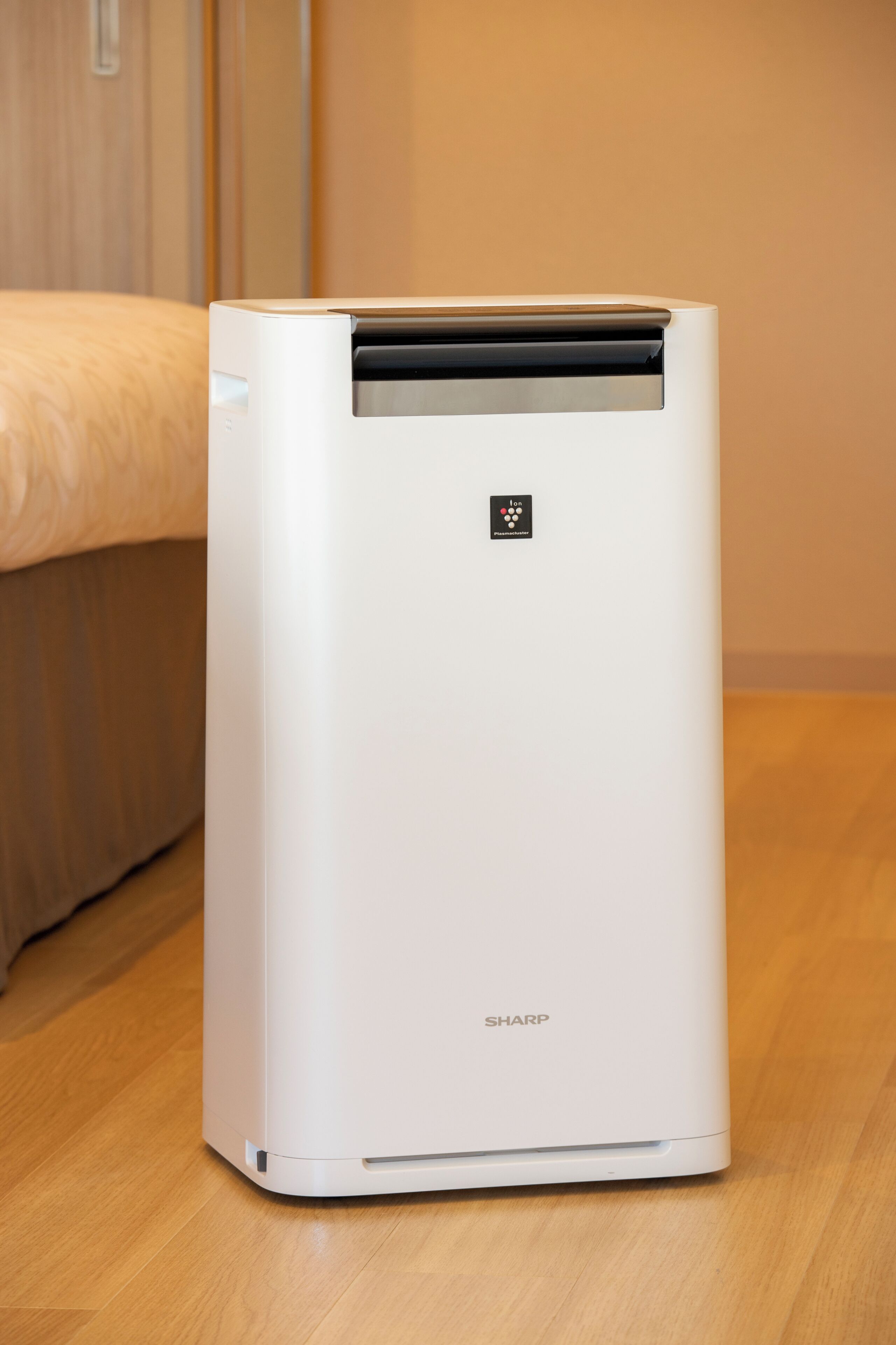 A white air conditioning unit with a control panel and the brand name 'SHARP' on the bottom.