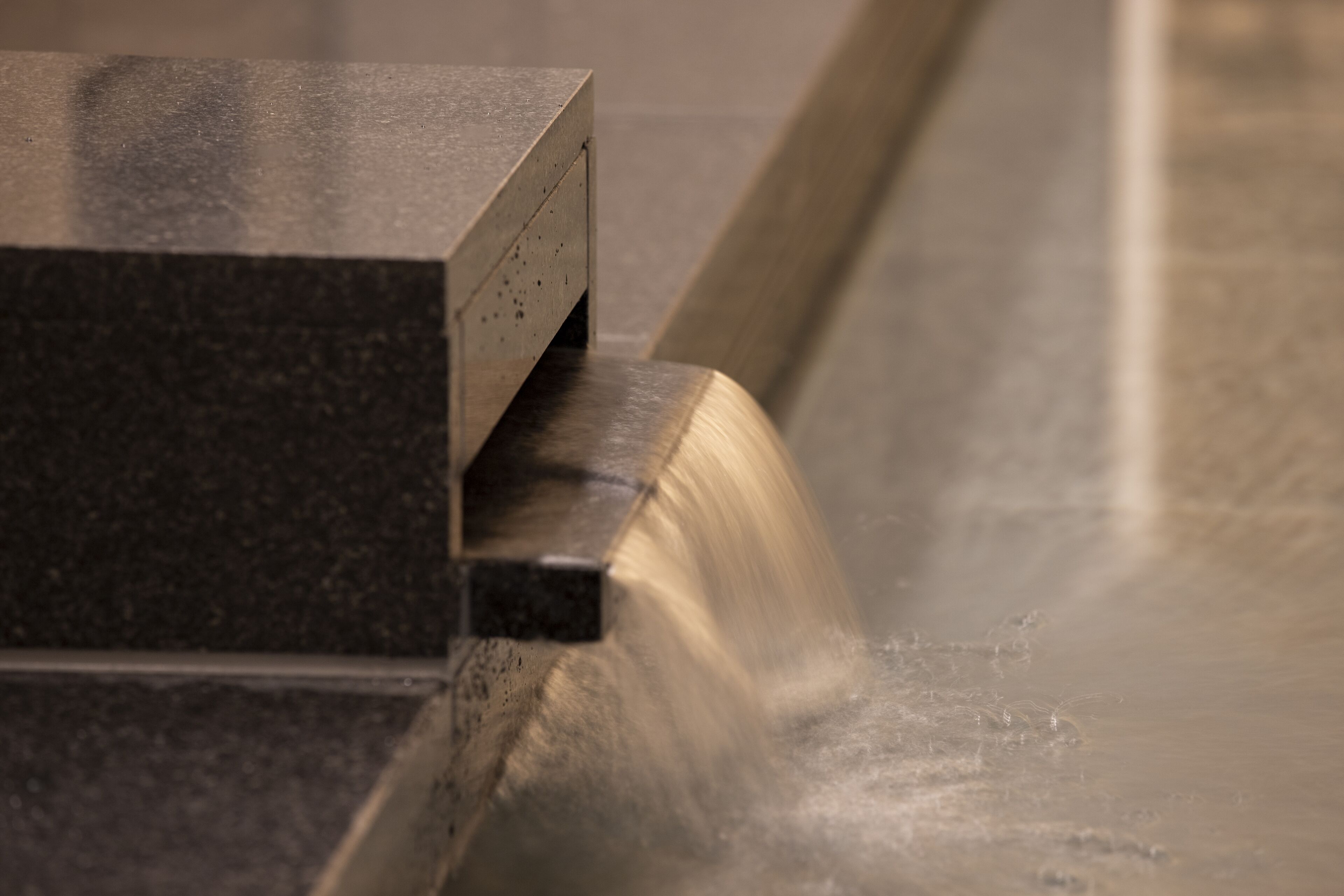 A close-up of a metallic surface with a curved edge, likely part of a piece of furniture or equipment.