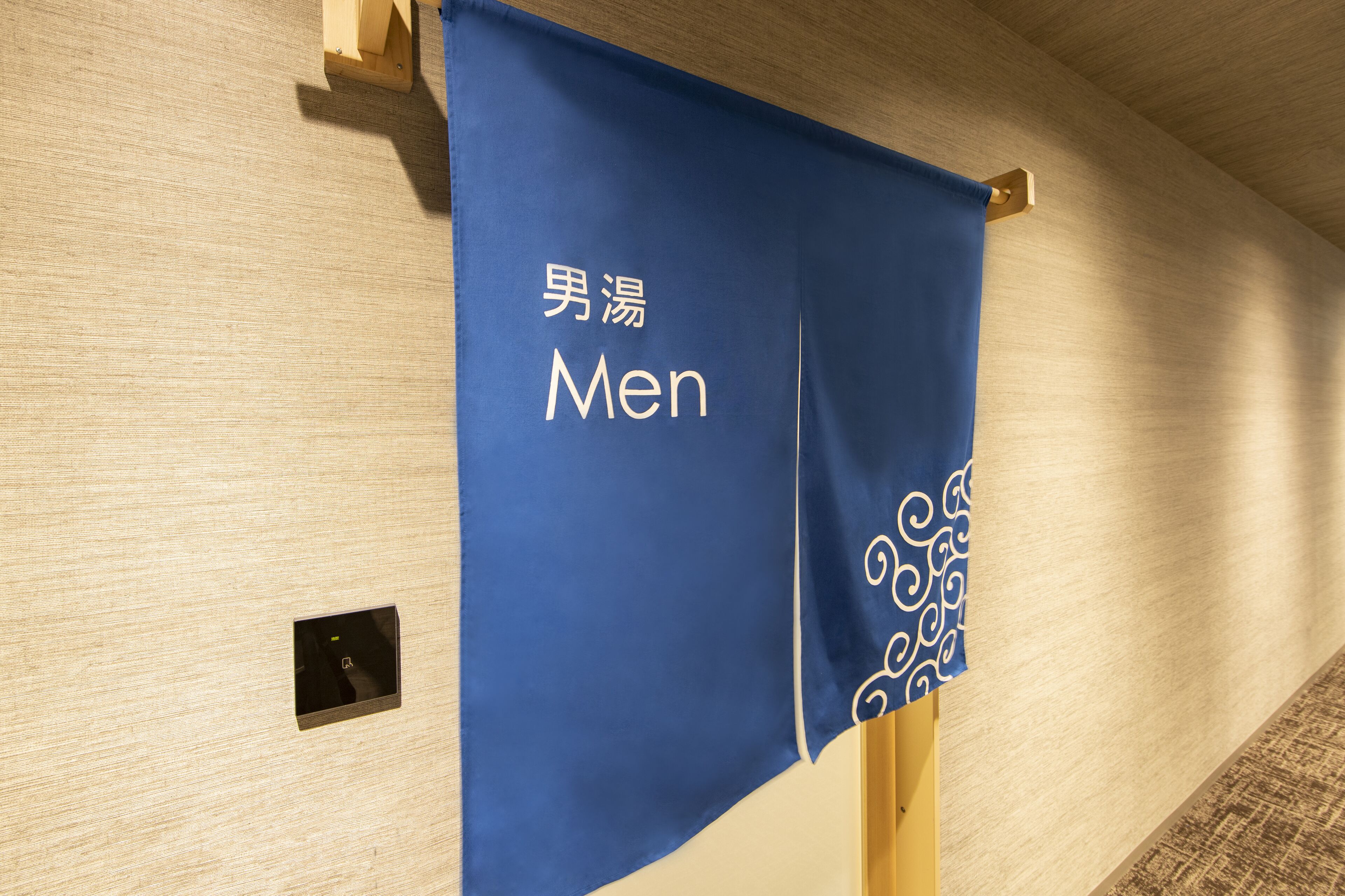 A blue banner with the word "Men" and Chinese characters on a wooden wall.