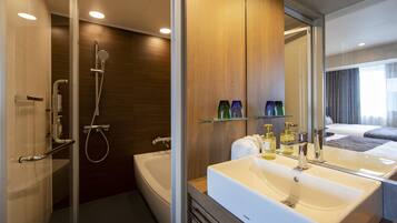 A modern bathroom with a large bathtub, a separate shower area, and a vanity with a mirror.