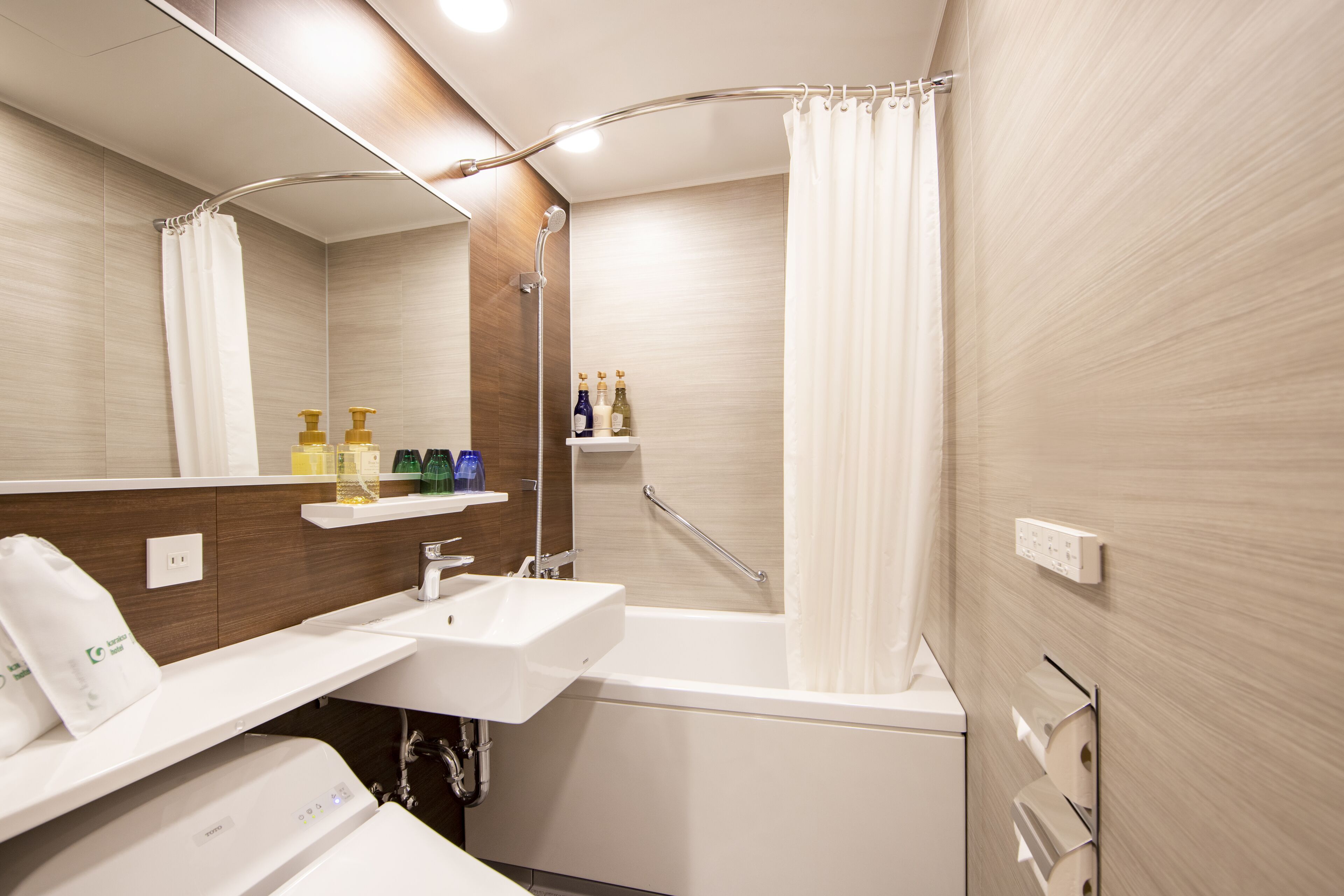A modern bathroom with a bathtub, two sinks, a shower, and a vanity with a mirror.