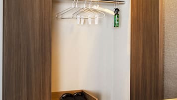 Un armario interior pequeño con muebles de madera, una barra para colgar ropa y un cajón de almacenamiento.