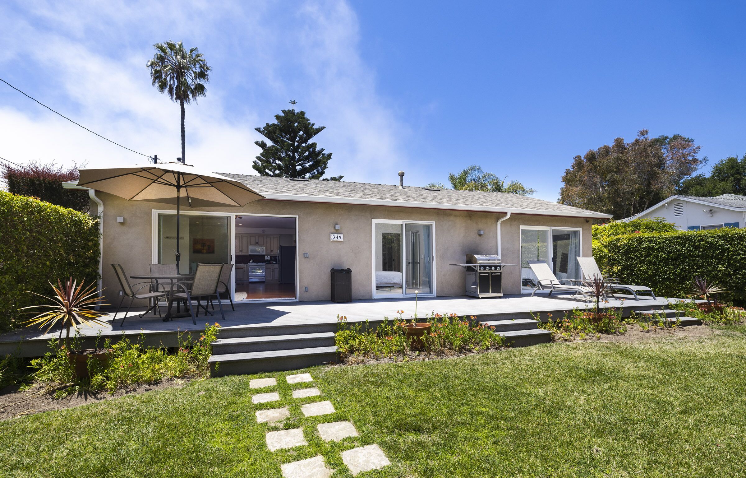 Front yard deck and BBQ invites guests to enjoy a meal outside or soak up the sun on the patio loungers.