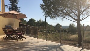 An outdoor patio with a table and chairs, a grill, and a view of the surrounding landscape. - Delightful family friendly villa with new private & heated pool   (Cébazan)