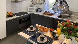 Una cocina moderna con una isla central, microondas, tostadora y lavaplatos.