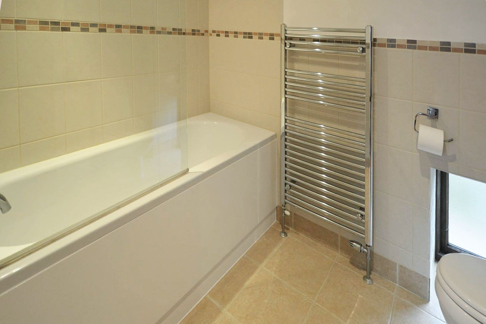 Een badkamer met een badkuip, een douchecabine van glas en een toilet.