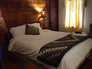 Restful retreat with a cozy bed, wooden headboard, and a lamp on the nightstand.