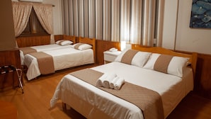 A hotel room with two beds, a wooden floor, a window with curtains, a nightstand, and a painting on the wall. - Pousada Encantos de Gramado (Gramado)