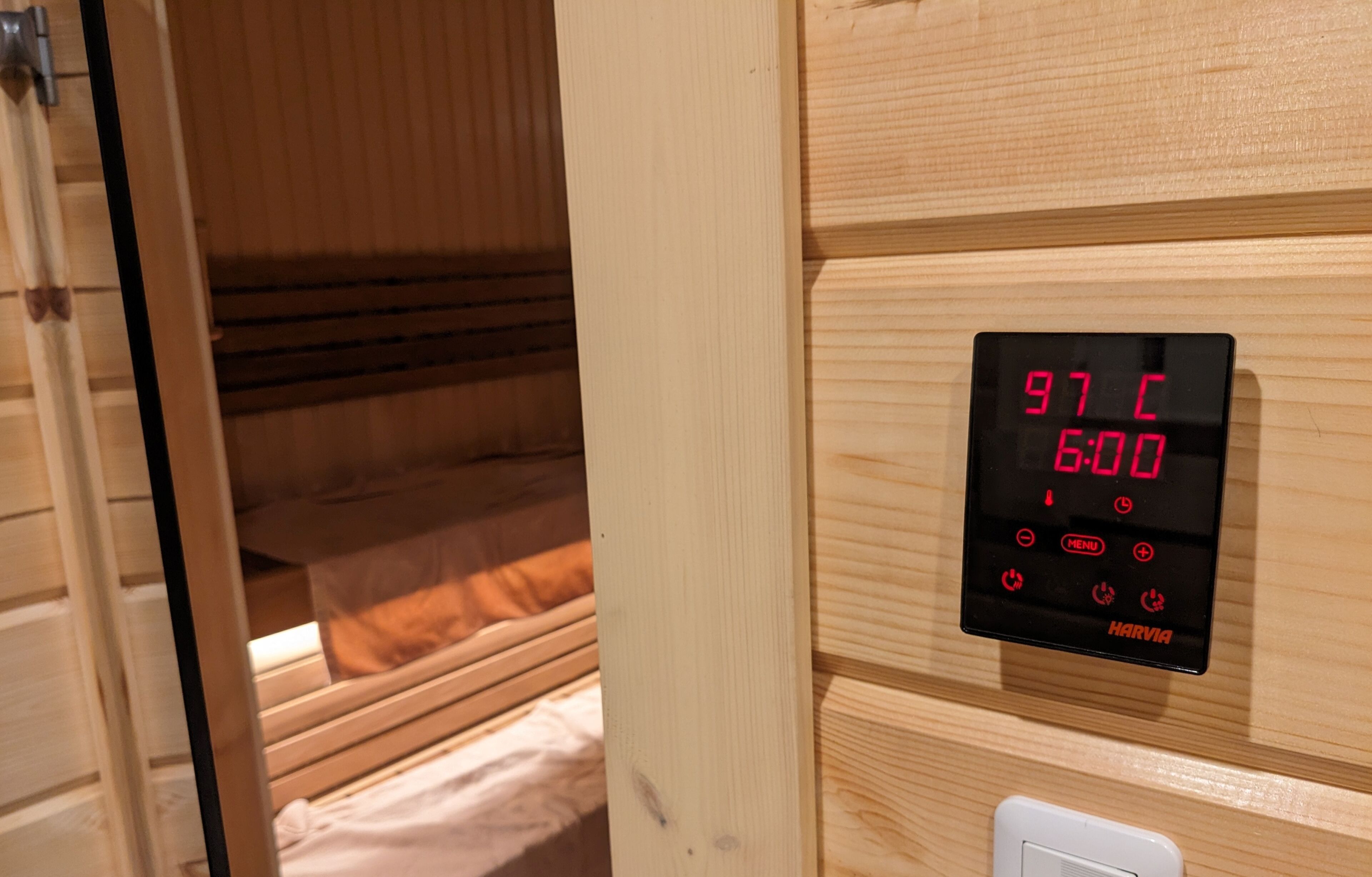 A digital thermostat displaying 97°C and 6:00, indicating room temperature and time.